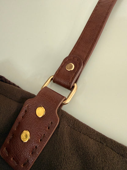 Close up of brown strap, gold hardware and handmade crochet bag construction