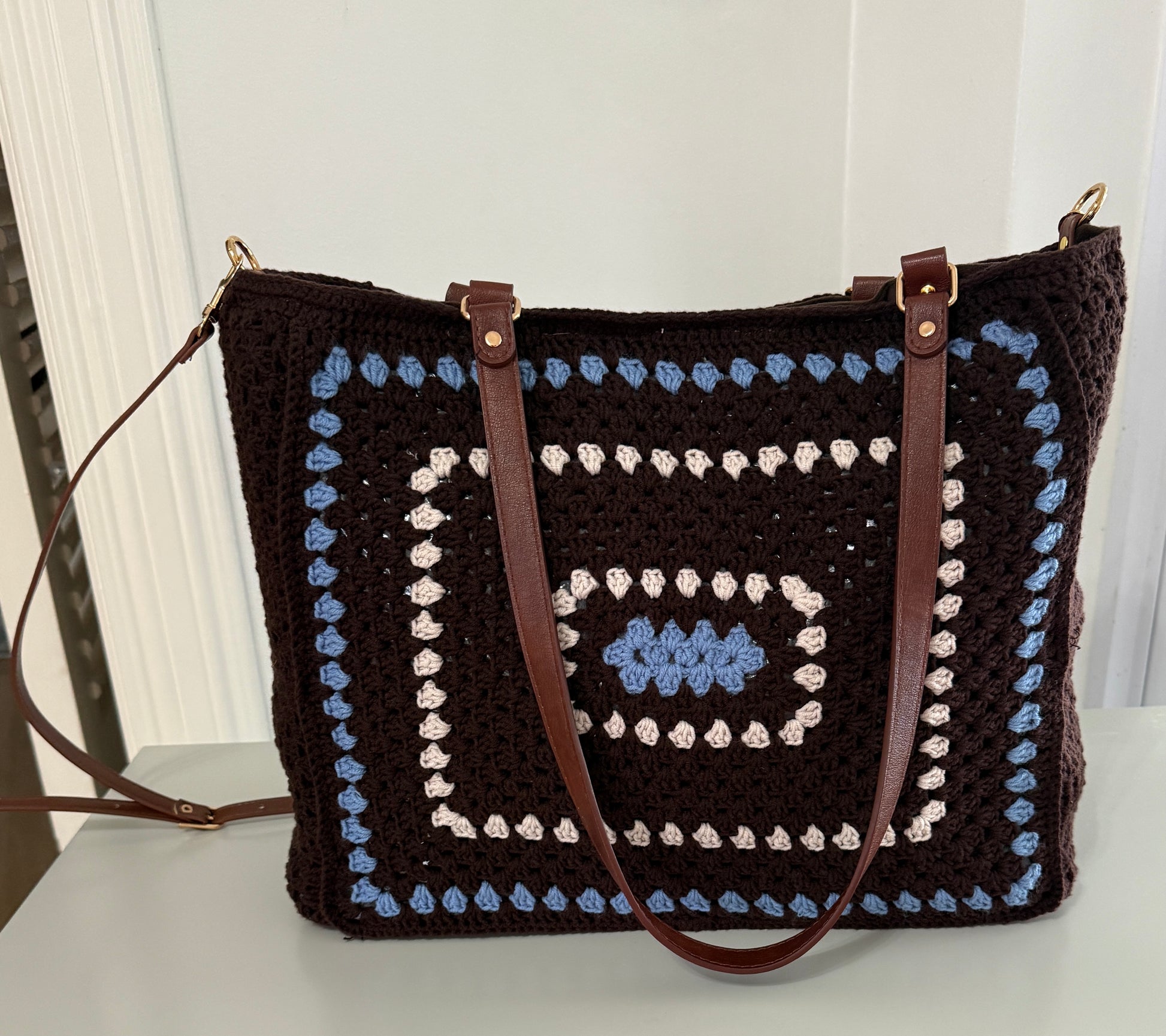 Brown and blue crochet tote bag with structured shape and spacious design