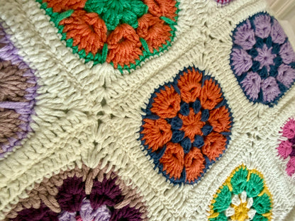 Detailed view of colourful handmade granny square crochet motifs on cream tote bag