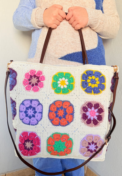 Large cream granny square crochet tote bag held by top handles with detachable crossbody strap