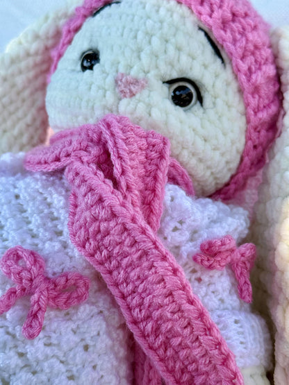 Close-up of pink crochet bow details on the handmade bunny’s white crochet dress