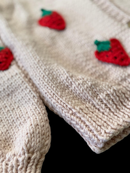 Close-up of 3D red strawberry appliqués hand-sewn with cotton yarn.