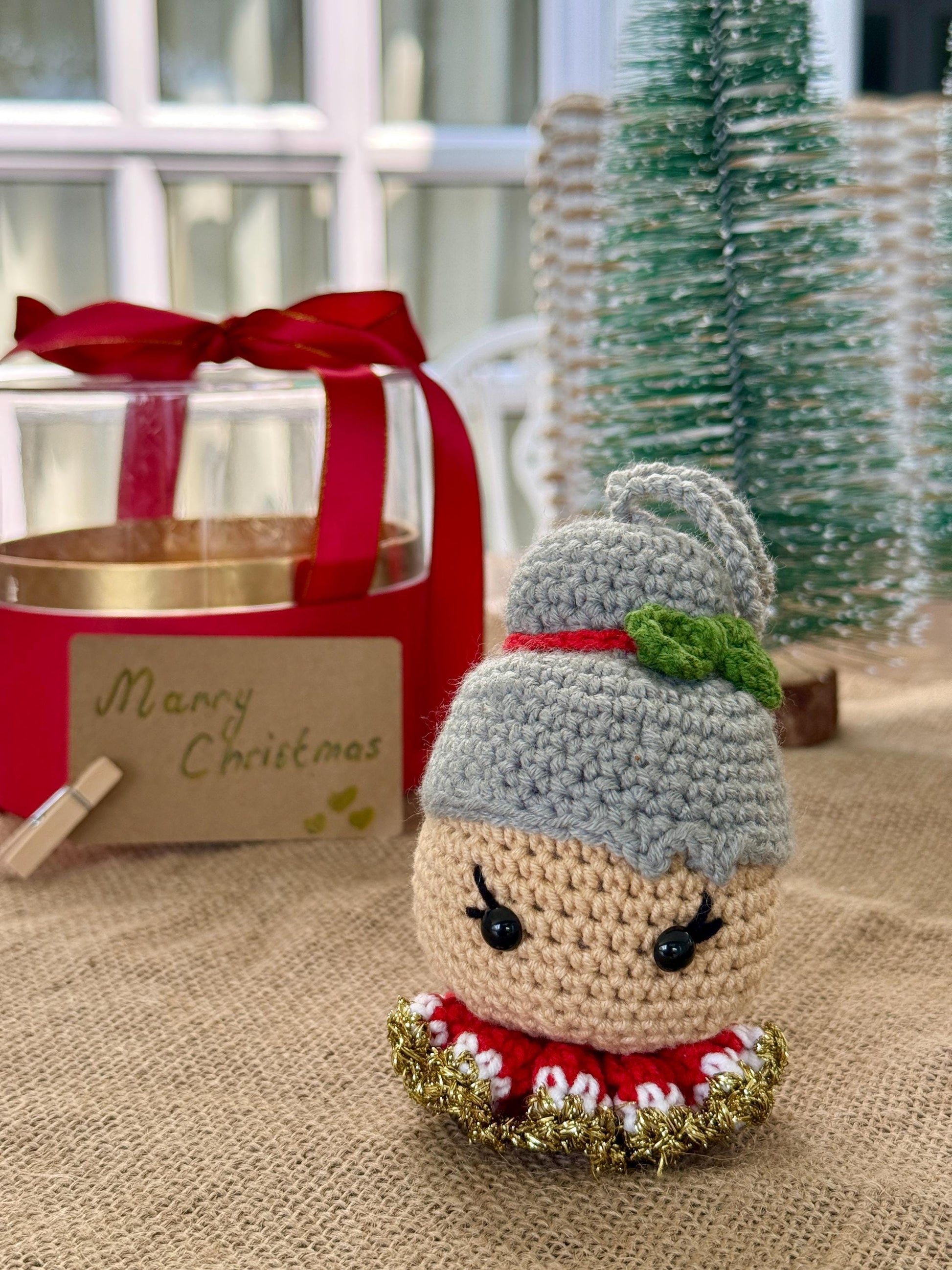 Crochet Mrs Claus ornament with green collar and bun hair – handmade cotton Christmas bauble decoration.